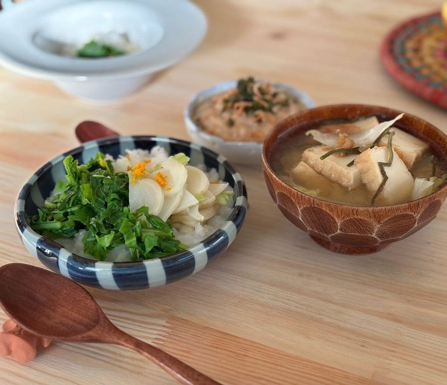 木のテーブルに並んだ丼と汁物